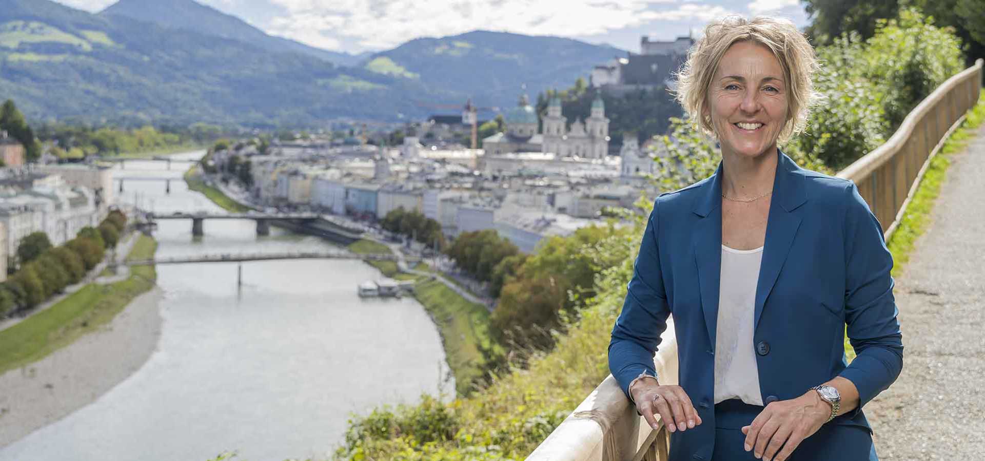 Sabine Wolfsgruber, im Hintergrund die Silhouette von Salzburg, Salzach und den umliegenden bergen © Neumayr